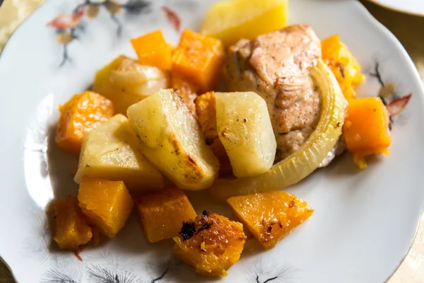 Hühnchen mit Kartoffelscheiben und einem Kürbis auf dem Teller gebacken — Stockfoto