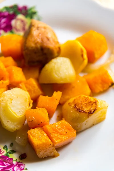 Hühnchen mit Kartoffelscheiben und einem Kürbis auf dem Teller gebacken — Stockfoto