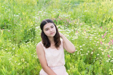 Kız zengin çayır üzerinde oturur