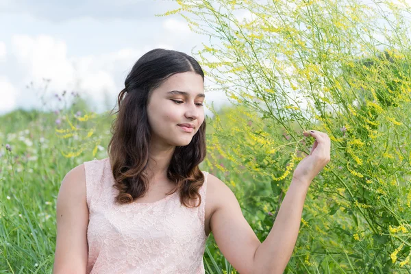 Jong meisje laat rusten op de weide in de zomer — Stockfoto