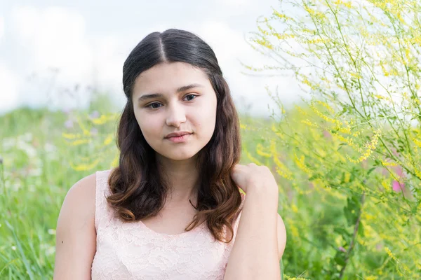 Junges Mädchen ruht sich im Sommer auf Wiese aus — Stockfoto