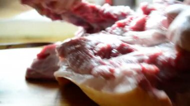 Kadın domuz leşini parçalar halinde keser.