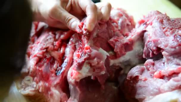 Женщины режут большой кусок свинины — стоковое видео