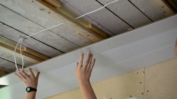 Deux travailleurs fait le plafond des panneaux MDF — Video