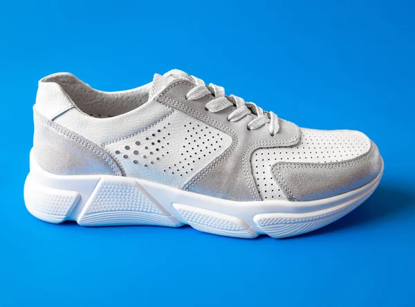 Vit Kvinnors Läder Sneaker Blå Bakgrund — Stockfoto