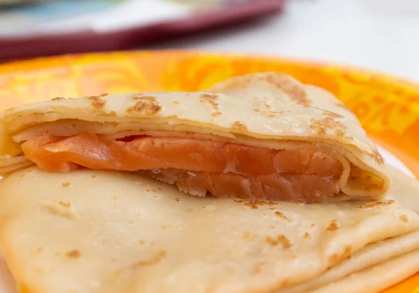 Pfannkuchen mit Lachs auf einem gemusterten Teller. Essenskonzept der Pfannkuchenwoche — Stockfoto