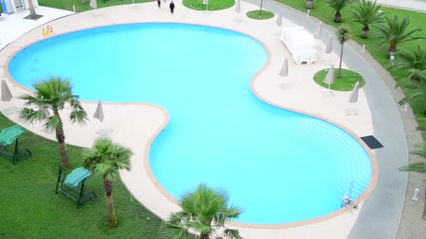 Sochi, Rusia - 30 de mayo. 2019 Vista superior de la piscina con agua. Dos chicas prueban el agua — Vídeos de Stock