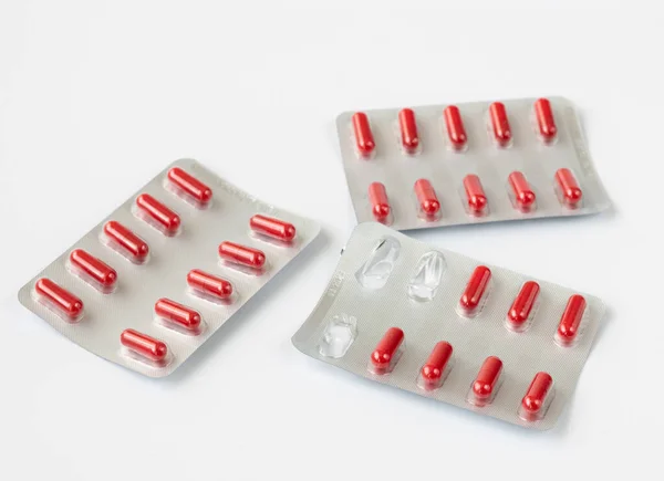 Red capsules in a blister - tabletted medicinal substance — Stock Photo, Image