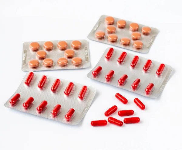 Red capsules in a blister - tabletted medicinal substance — Stock Photo, Image