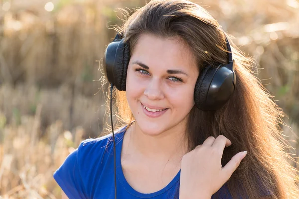 Dziewczyna słuchanie muzyki w dziedzinie — Zdjęcie stockowe