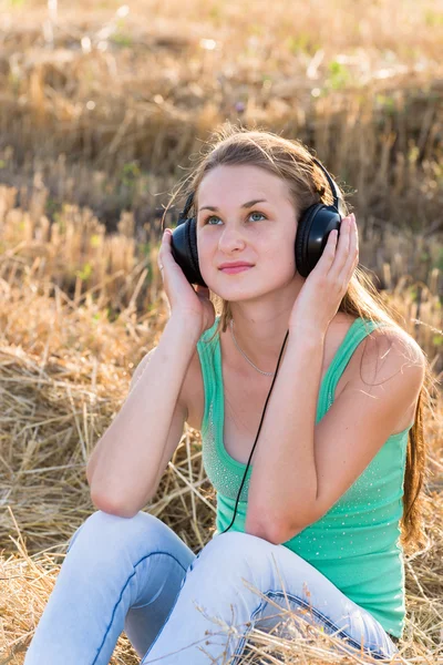 Dziewczyna słuchanie muzyki w dziedzinie — Zdjęcie stockowe