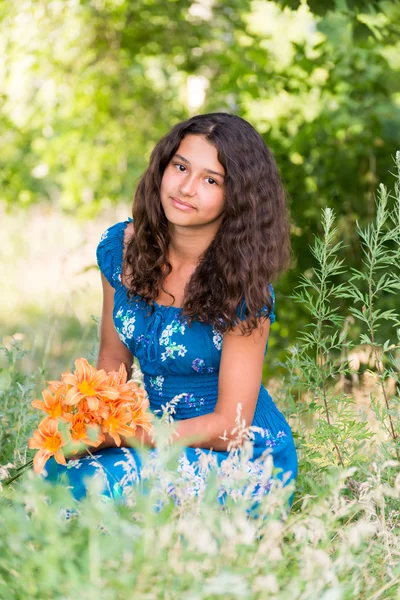 Ragazza con un mazzo di gigli nel parco — Foto Stock