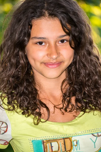 Menina bonita nova com um cabelo encaracolado ao ar livre — Fotografia de Stock