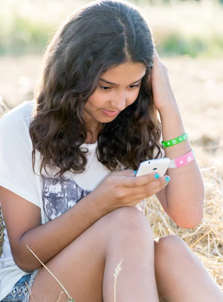 Adolescente menina escreve um sms no campo — Fotografia de Stock