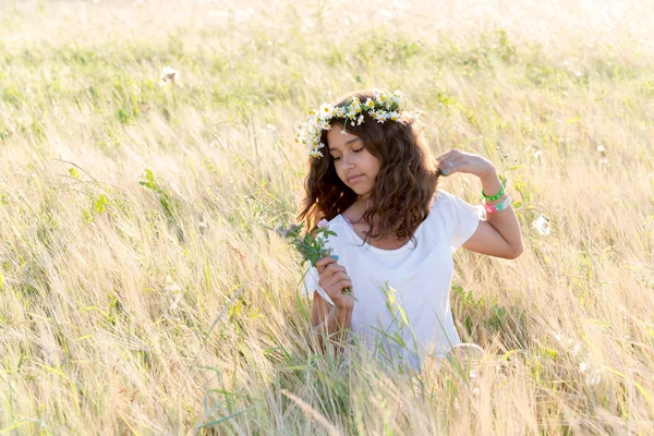 Adolescent fille avec une couronne de marguerites dans champ — Photo