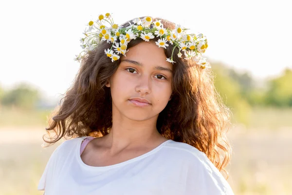 フィールドのヒナギクの花輪を持つ十代の少女 — ストック写真