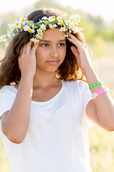 Tiener meisje met krans van madeliefjes — Stockfoto