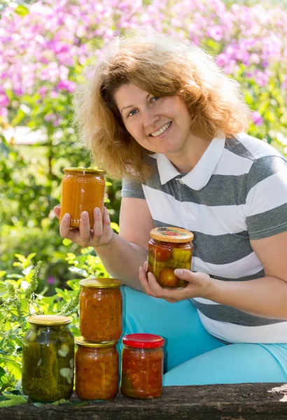 Домохозяйка с домашними консервами в саду — стоковое фото