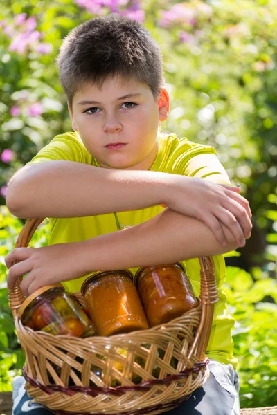 Pojke och hem konserverade grönsaker i naturen — Stockfoto