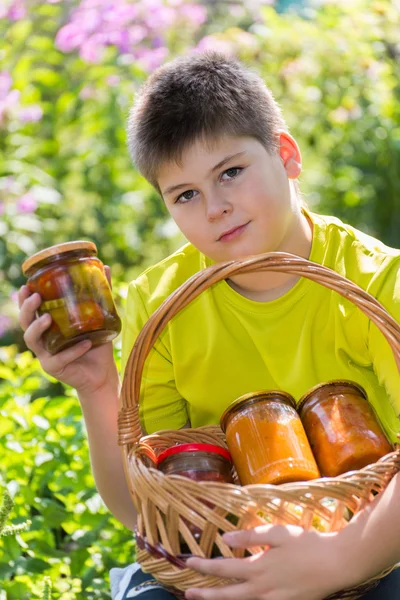 Boy and home canned vegetables in nature — Stock Photo, Image