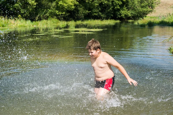Full 10 anni ragazzo nuotare nel fiume — Foto Stock
