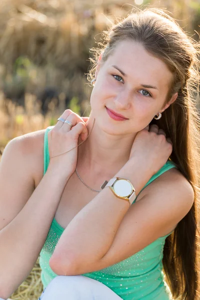 Tiener meisje rusten in een veld — Stockfoto