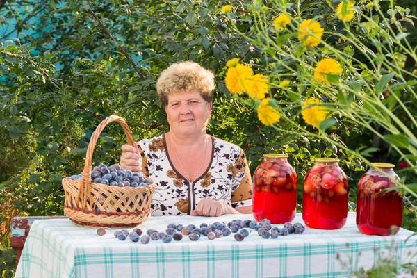 Femme âgée avec un pot de compote de prunes — Photo