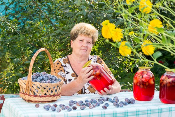 Літня жінка з баночкою сливового компоту — стокове фото