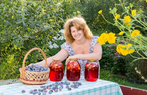 Donna con composta di prugne in giardino — Foto Stock