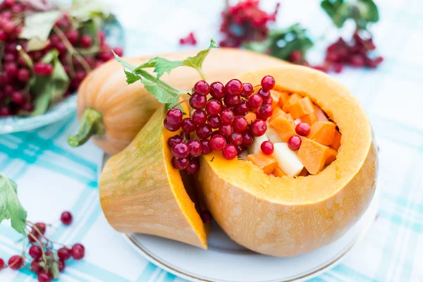 Pumpkin stuffed with raw vegetables and viburnum — Stock Photo, Image