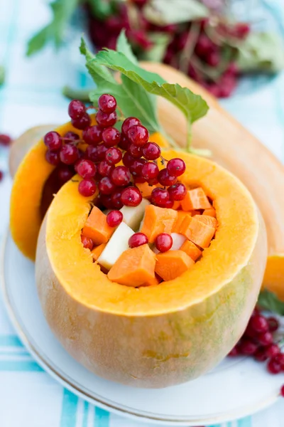 Pumpkin stuffed with raw vegetables and viburnum — Stock Photo, Image