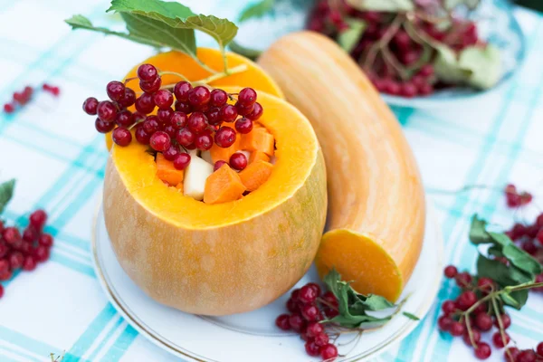 Pumpkin stuffed with raw vegetables and viburnum — Stock Photo, Image
