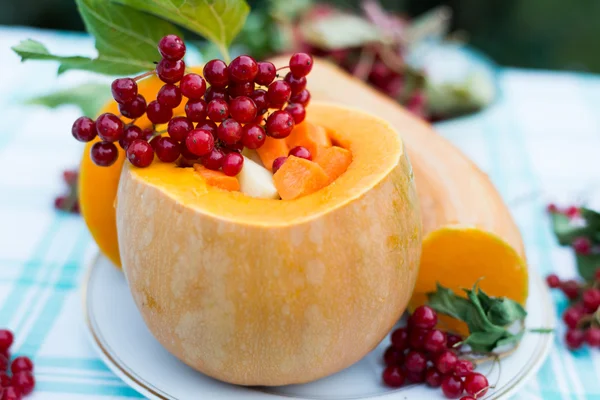 Pumpkin stuffed with raw vegetables and viburnum — Stock Photo, Image