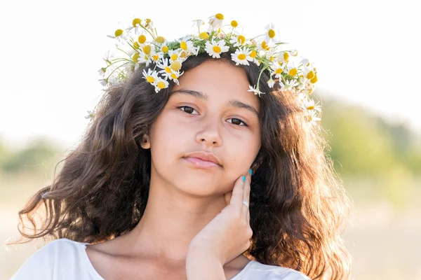 Adolescente com uma coroa de margaridas no campo — Fotografia de Stock