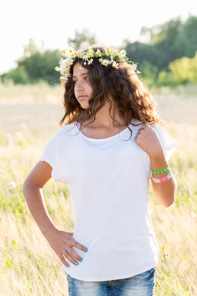 フィールドのヒナギクの花輪を持つ十代の少女 — ストック写真