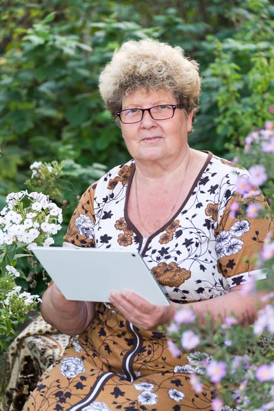 Seniorin nutzt digitales Tablet im heimischen Garten — Stockfoto