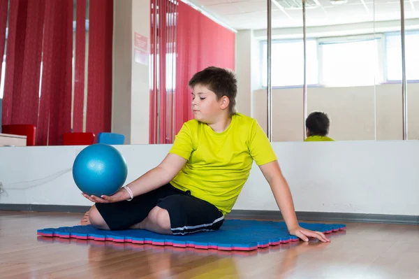 Boy does exercise with the ball — Stock Photo, Image