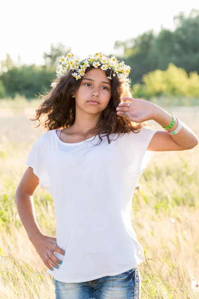 Chica adolescente con una corona de margaritas en el campo —  Fotos de Stock