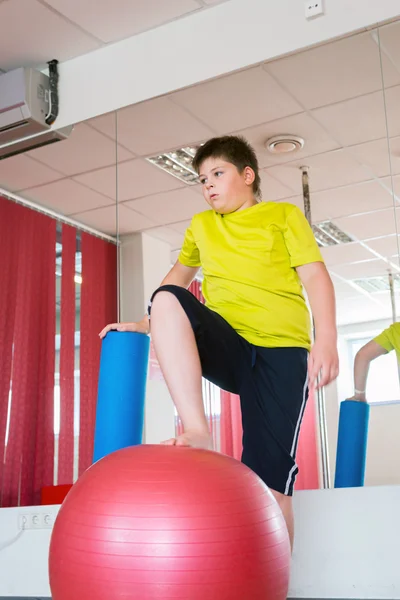 Garçon fait de l'exercice avec la balle dans la salle de gym — Photo