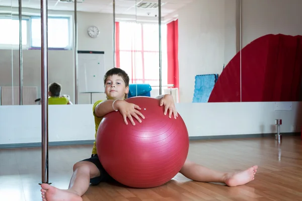 Αγόρι άσκηση με την μπάλα στο γυμναστήριο — Φωτογραφία Αρχείου