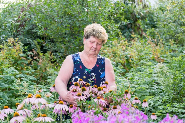 Зрелая женщина с цветами в саду — стоковое фото