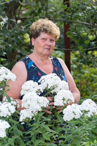 Mulher madura com flores no jardim — Fotografia de Stock