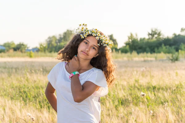 フィールドのヒナギクの花輪を持つ十代の少女 — ストック写真