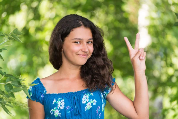 Adolescente chica mostrando signo en la naturaleza — Foto de Stock