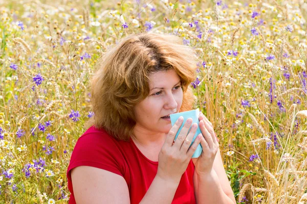 Tlustá žena s alergickou rýmou v louce — Stock fotografie