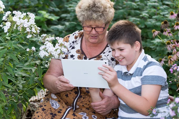 Oma mit Enkel schaut Tablet-PC — Stockfoto