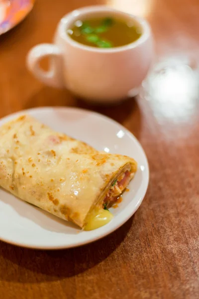 Pancake stuffed with meat and tea — Stock Photo, Image