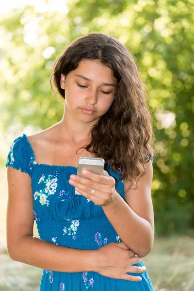 Jeune fille avec un téléphone dans le parc — Photo