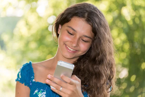 Дівчина-підліток з телефоном в парку — стокове фото