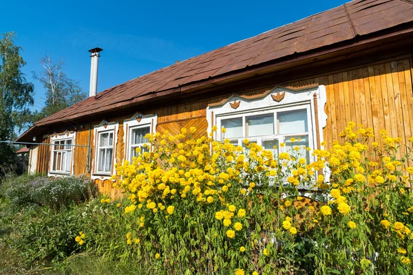 Gelbe Blumen vor dem Dorfhaus — Stockfoto